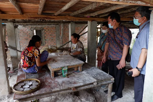 Ogan Ilir, Indonesia - October 27, 2021: Three men having a discussion with two women at work about Traditional Food