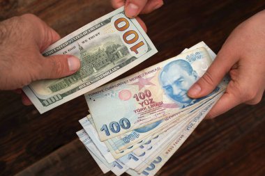 İnsanlar bir sürü Türk lirası banknotunu 100 dolara değiştiriyor. Türk ekonomisi, döviz kuru, borsa, finans haberleri kavramı.