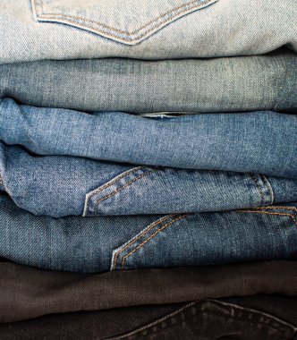 Farklı renklerde kotlar yığılmış. Dükkandaki Denim. Kot yığını. Doku ve arka plan için Denim. Satış konsepti. Kara Cuma indirimi.