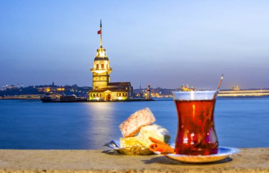 Arka planda Maiden 's Tower' ın (Kiz kulesi olarak da bilinir) muhteşem manzarası ve önünde renkli Türk zevki olan geleneksel Türk çayı. İstanbul eğlenceleri.