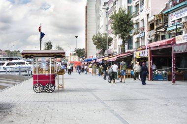 ISTANBUL, TURKEY - 10 Eylül 2019: Karaköy Embankasında (Karaköy İskelesi) geleneksel Türk sokak yemekleri satan adam. İnsanlar deniz kenarında dinleniyor..