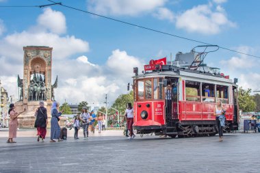 İSTANBUL, TURKEY - 10 Eylül 2019: Taksim Meydanı 'ndaki Cumhuriyet Anıtı' nın önündeki nostaljik tramvay. İstanbul 'da ünlü ve popüler bir turistik yerdir..