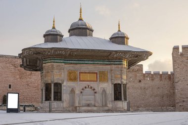 Sultan Ahmed Çeşmesi 'nin panoramik manzarası. Kış günü çok kar yağacak. Topkapı Sarayı 'nın İmparatorluk Kapısı, Sultanahmet İlçesi, İstanbul, Türkiye ve boş pankart. Model yap. Uzayı kopyala Soğuk Kış Günü.