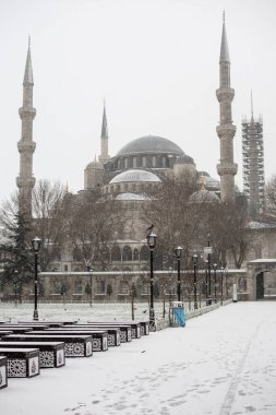 Kış günü İstanbul, Türkiye 'de çok kar yağan Mavi Cami' nin (Türkçe Sultanahmet Camii) yanında güneş doğuyor. Ocak 2021.
