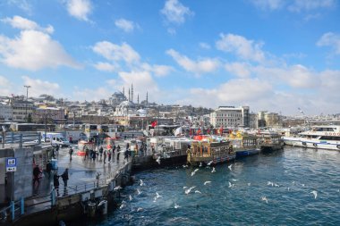 ISTANBUL, TURKEY - 25 HAZİRAN 2022: Eminonu rıhtımında otantik tekneler, soğuk kış günlerinde ünlü geleneksel balık sandviçleri satıyorlar.. 