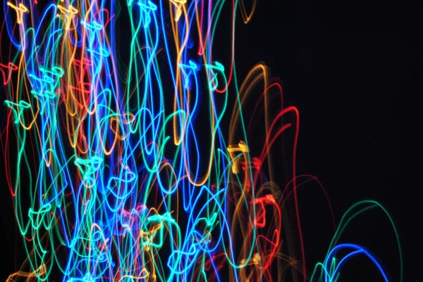 Multicolored light in motion in a dark room.