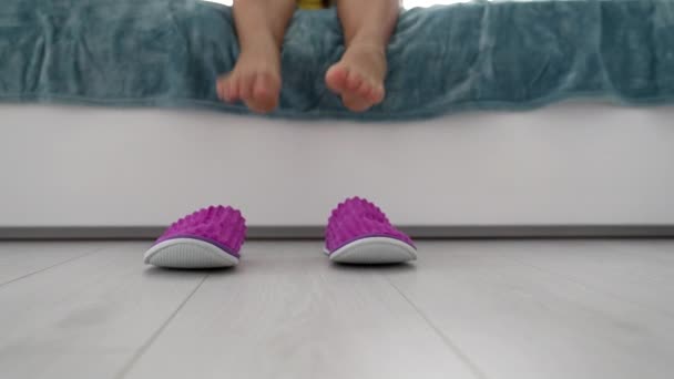 Kvinnliga fötter i rosa sovrum tofflor i sängen på golvet, husskor — Stockvideo