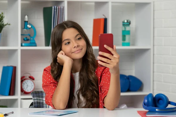 Glad unge lång lockigt hår tar selfie foto på smartphone i klassrummet, vloggning — Stockfoto