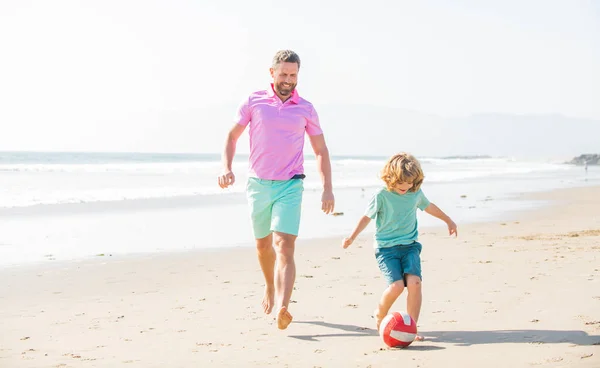 Criança e pai correndo na praia em férias de verão com bola, felicidade — Fotografia de Stock