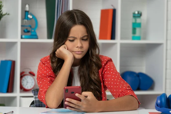 Chica adolescente seria ocupada con el teléfono móvil, la infancia —  Fotos de Stock
