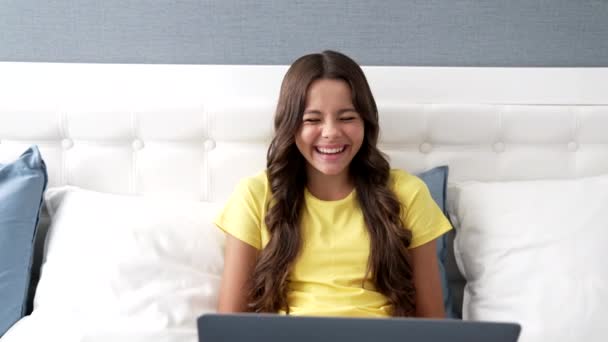 Gülen komik çocuk bilgisayarla yatağa otur, ağır çekim, çocukluk — Stok video