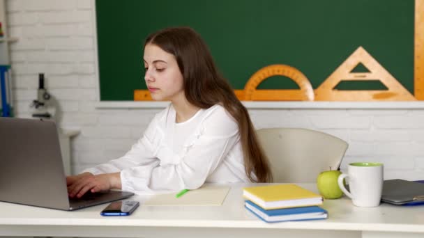 Серьезные девушки используют ноутбук в школе, образовательные технологии — стоковое видео