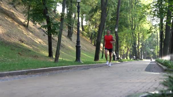 Atleta homem enérgico correndo em parte no ar fresco, resistência — Vídeo de Stock