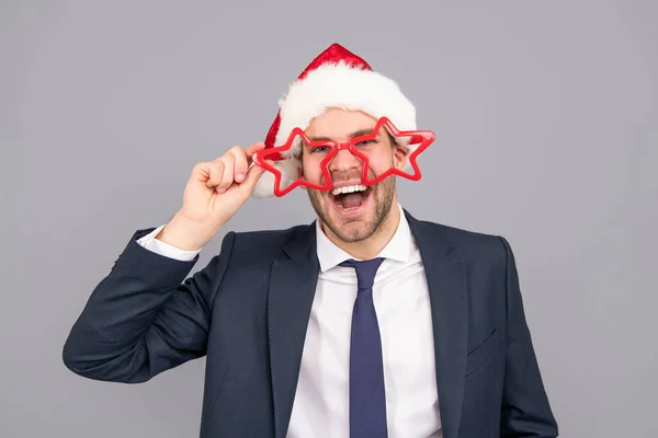 Homem feliz em terno de negócios e chapéu de Papai Noel e óculos de festa, festa de ano novo — Fotografia de Stock