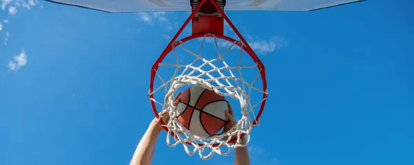 Ballon de basket-ball dunk à travers anneau net avec les mains, gagner — Photo