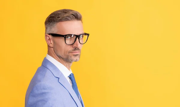 Hombre de negocios maduro en chaqueta elegante y gafas graduadas sobre fondo amarillo, espacio para copiar, gerente — Foto de Stock