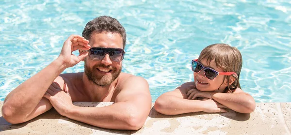 happy family of daddy and son having fun in summer swimming pool, vacation