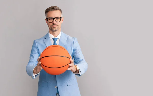 Hombre guapo mantenga pelota de baloncesto sobre fondo gris, espacio de copia, negocio — Foto de Stock