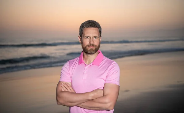 Летние каникулы. Красивый мужчина с бородой на закате над морем. небритый парень на утреннем пляже — стоковое фото