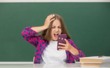 Sınıfta akıllı telefondan konuşan hayret verici çocuk, e-posta cevabı.