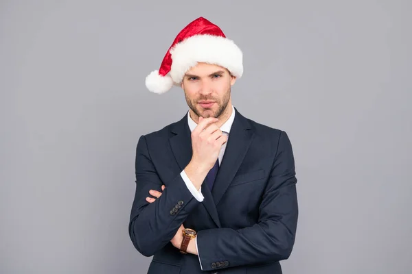 Biznesmen facet nosić santa kapelusz na szarym tle, Boże Narodzenie — Zdjęcie stockowe