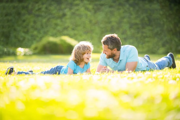 Feliz familia de papá e hijo niño relajarse en el parque de verano hierba verde, crianza de los hijos — Foto de Stock
