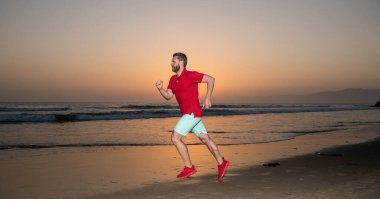 Acele et. Dayanıklılık ve dayanıklılık. Aktif bir sprinter. Spor atleti deniz batımında kazanmak için hızlı koşar.