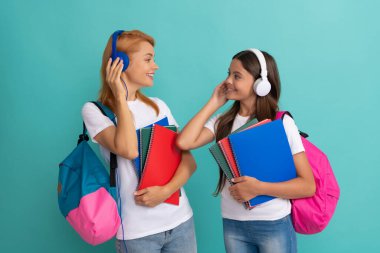 Anne ve kızının elinde defter var. Okula dönüyorum. çocukluk İnternet eğitimi.