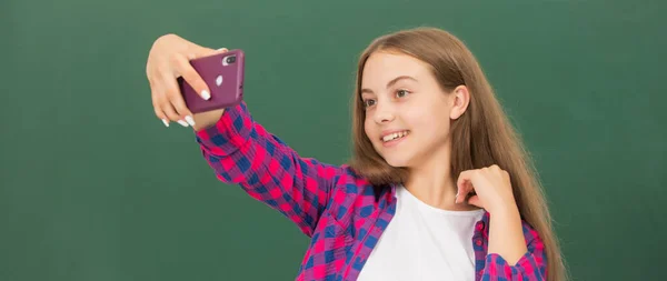 Vlogger med mobiltelefon i klassrummet. gör video blogg på smartphone. tonåring flicka blogga på telefon. — Stockfoto