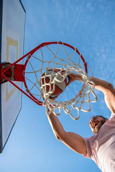 Hombre exitoso con pelota de baloncesto en la cancha. jugador de baloncesto profesional entrenamiento al aire libre. — Foto de Stock