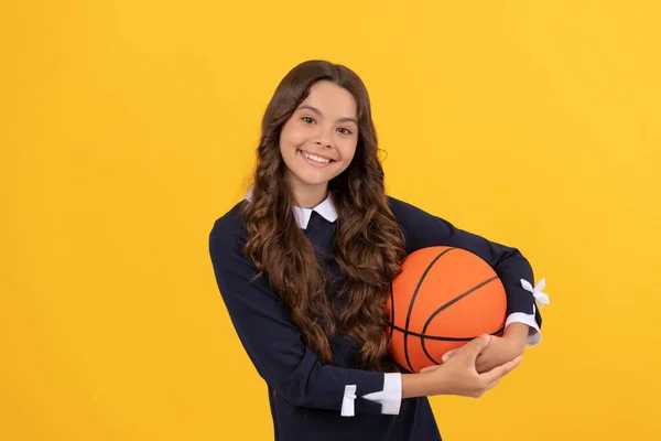 Sonriente niño mantenga pelota de baloncesto sobre fondo amarillo, baloncesto — Foto de Stock