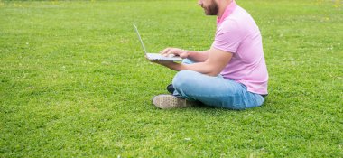 Yeşil çim, kopyalama alanı ve ağ yöneticisi hakkında blog yazmak için dizüstü bilgisayar kullanan kırpılmış işadamı