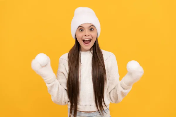 黄色い背景に雪玉の子供。幸せな子供時代。クリスマス休暇で10代の女の子. — ストック写真