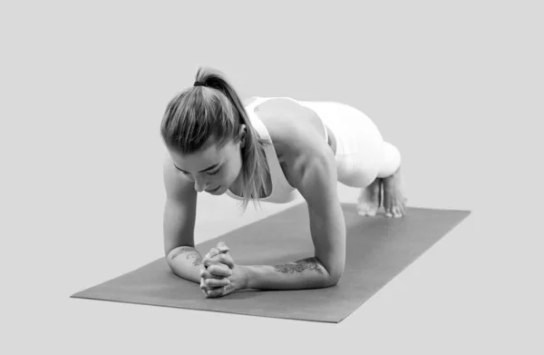 Girl in sportswear standing in plank for core muscles on fitness mat, training — Stock Photo, Image