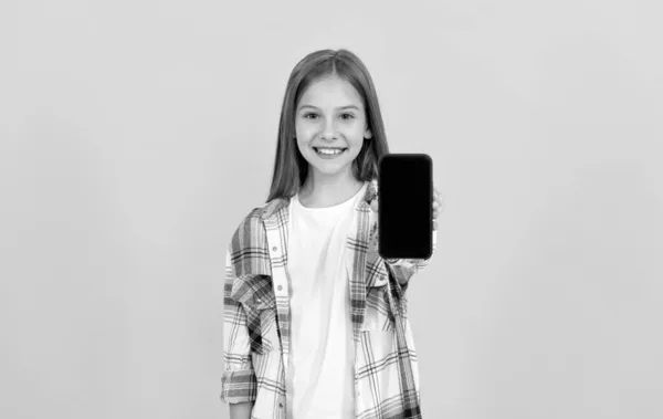 Happy kid presenteren product van moderne smartphone show scherm voor kopieerruimte, reclame — Stockfoto