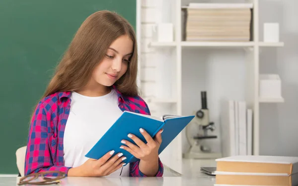 Lisede. Kitapçığı olan liseli kız. Yoğunlaşmış çocuk defter okuyor. Okula geri dön. — Stok fotoğraf