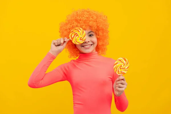 Pembe polonyalı turuncu saçlı mutlu kız çocuğu lolipop tutarken iyi eğlenceler. — Stok fotoğraf