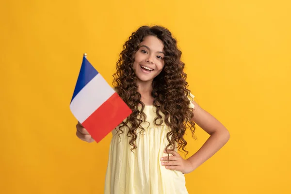 Šťastný dítě dlouhé kudrnaté vlasy držet francouzskou vlajku, francouzština — Stock fotografie