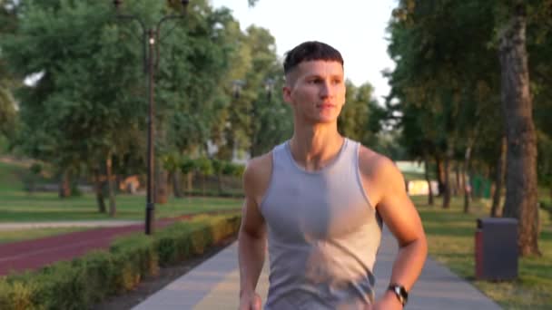 Muskularny mężczyzna sprinter działa w godzinach wieczornych odkryty zachód słońca, sport ćwiczenia — Wideo stockowe