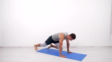 Kas yığını atlet dağcı spor paspası ve spor rutini üzerinde kalas egzersizi yapıyor.