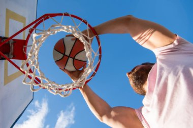 Profesyonel basketbolcu dışarıda antrenman yapıyor. Adamın spor motivasyonu var. spor ve hobi