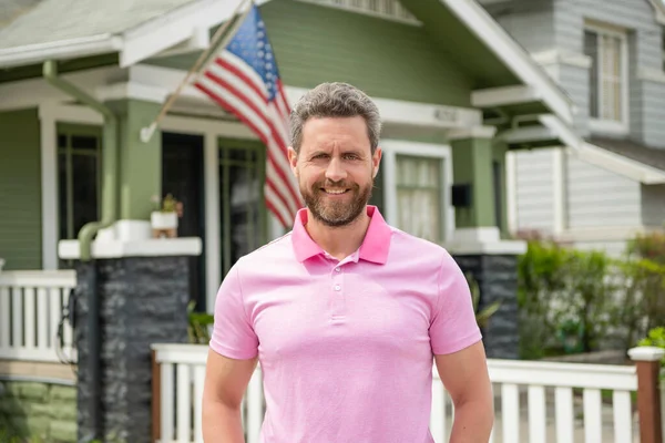 Happy bearded man realtor selling or renting house with american flag, real estate — Stock Photo, Image