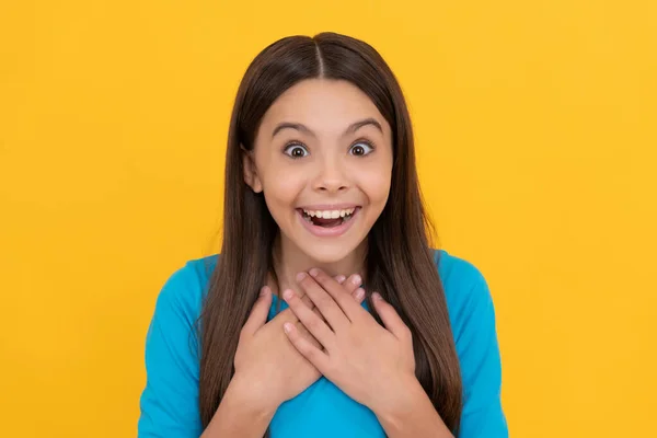 Surprised teen girl with long hair on yellow background, surprise — Stock Photo, Image