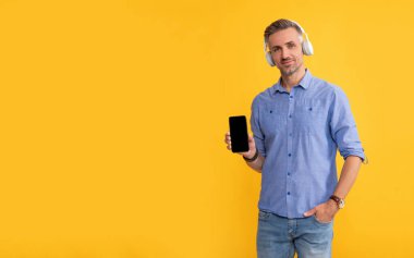 Müziği dinle ve telefonu tut. Modern hayat ve yaşam tarzı. Kulaklıklı adam..