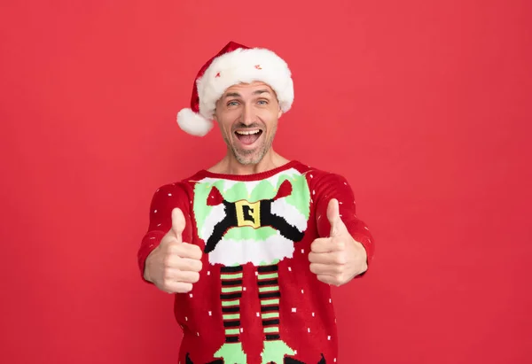 Щасливий чоловік Санта - Клауса усміхається, коли велично похвалює жест червоного кольору на Різдво. — стокове фото