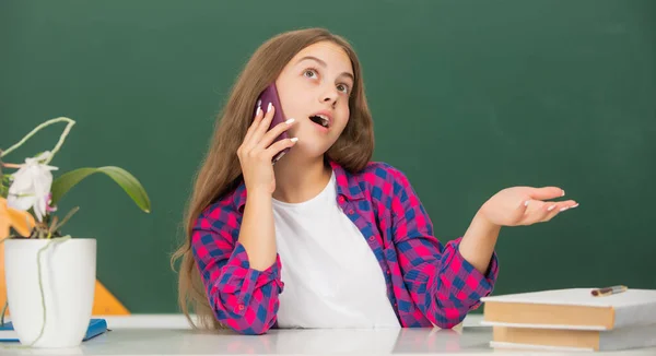 Enfant rêveur à l'école parler au téléphone sur fond de tableau noir, conversation — Photo