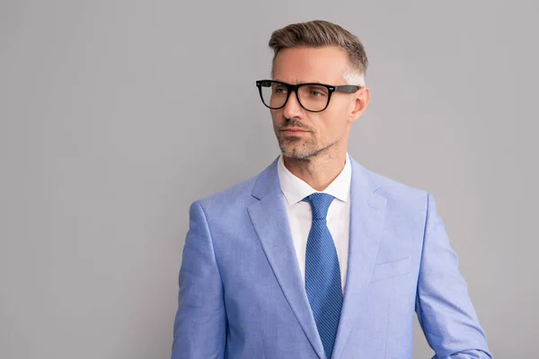 Hombre de negocios maduro en chaqueta elegante y gafas graduadas sobre fondo gris, espacio para copiar, ropa formal — Foto de Stock
