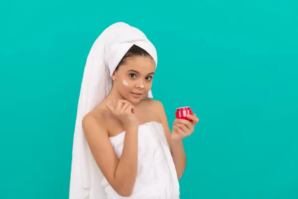 Presentatie cosmetische product voor tiener. Het kind gebruikt gezichtscrème. jong meisje houden haarmasker. — Stockfoto