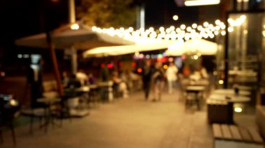 Gece boyunca yürüyen insanların bulanık görüntüsü Bokeh 'i aydınlattı.