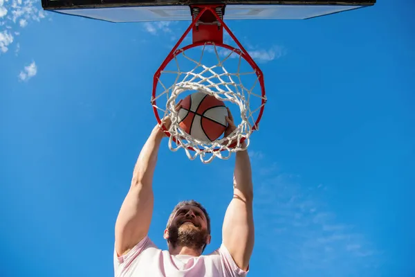 Jogador homem alegre jogar bola de basquete através da cesta, motivação — Fotografia de Stock